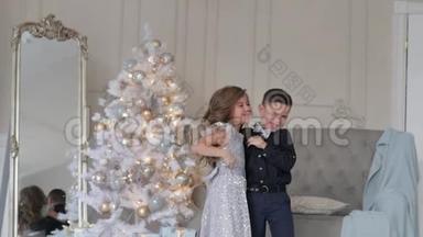 男孩和女孩在圣诞树背景上特写。 穿着<strong>漂亮衣服</strong>的孩子