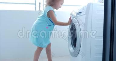 可爱的孩子在洗衣机里看。 气缸旋转机。 概念洗衣机，工业