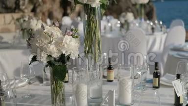 花瓶里放着白色的花，放在桌子上，在海上庆祝。