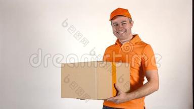 穿橙色制服的送货员送了一个大盒子。 <strong>浅灰色背景</strong>，4K摄影棚拍摄
