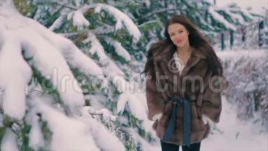 穿着棕色皮毛大衣的布鲁内特女孩刷着冬天散步时的慢动作