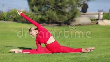 穿着红色乳胶服装的金发女郎正在做瑜伽练习。