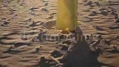 穿着黄色衣服的女人在海滩上散步