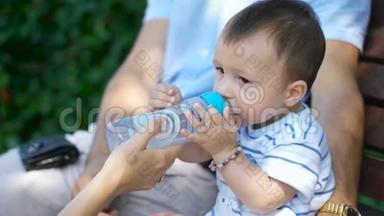 孩子用瓶子里的水解渴。