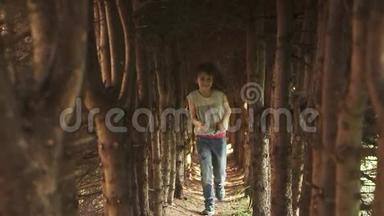 小女孩穿过树洞。 神秘而神奇的森林里的孩子。 慢动作