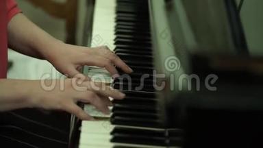 女孩`钢琴键盘上的手。 女孩弹钢琴，合上钢琴。 手放在钢琴的白键上