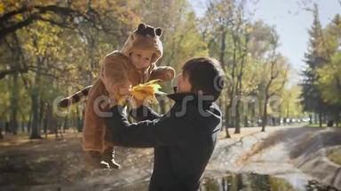 幸福的家庭<strong>爸爸</strong>在秋天的落叶公园里把孩子扔上<strong>去</strong>散步。