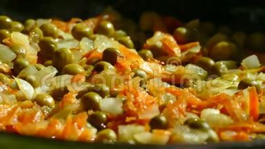 在煎锅里，用洋葱和胡萝卜炒。 在煎锅中加入青和冷冻红辣椒。