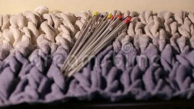 一<strong>套用</strong>于编织的金属针躺在一件针织毛衣拉洛上。