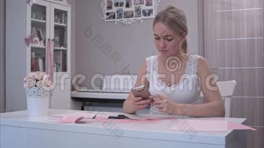 年轻女子一边用手机剪纸蝴蝶