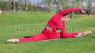 穿着红色乳胶服装的金发女郎正<strong>在做瑜伽</strong>练习。