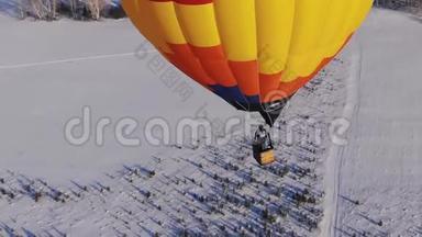 空中拍摄的人们乘<strong>坐</strong>一个大明亮的<strong>气球</strong>飞越冬季森林。