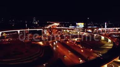 4K. 高速公路立交的鸟瞰图，夜间繁忙的城市交通在道路上超速行驶。 连接网络