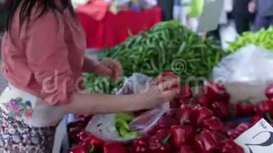 今年夏天，一位戴着眼镜的妇女在土耳其市场上试图选择红辣椒