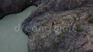 空中飞行。 带背包的女孩旅行者沿着<strong>山崖</strong>散步。 女游客去远足了。 西伯利亚阿尔泰