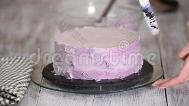 用<strong>紫色</strong>奶油盖装饰<strong>蛋糕</strong>的过程。 甜点师使用糕点抹刀将饼干奶油切等。