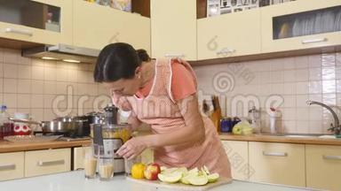 女家庭主妇在厨房用水果和<strong>榨汁</strong>机准备做新鲜果汁。 健康饮食、烹饪