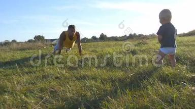 小<strong>宝宝</strong>站在草地上的青草上，看着爸爸做俯卧撑。<strong>运动</strong>员在做俯卧撑