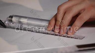 人的建筑师用铅笔在办公桌上的一张大纸上画一个平面图、图形、设计、几何形状。 黑色