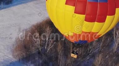 空中拍摄的人们乘<strong>坐</strong>一个大明亮的<strong>气球</strong>飞越冬季森林。