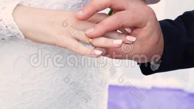 结婚典礼上，新郎把金戒指戴在新娘`手指上