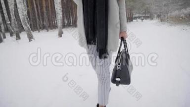 带着雨伞的漂亮年轻女人正在<strong>冬</strong>天的公园里户外散步。 慢动作。 <strong>时尚冬</strong>季肖像