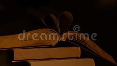 一叠书，上面有一本打开的书。 从书单中创造<strong>心灵</strong>。 心由床单制成的书被突出。