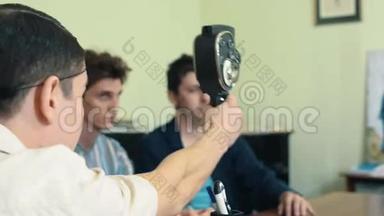 男士发网使用复古8毫米相机在办公室拍摄两名工人