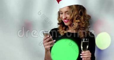 女模特在照相馆里用的是手机；女模特戴着圣诞老人€™帽子，拿着一杯香槟；