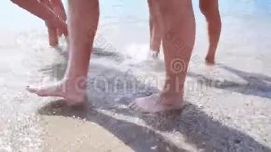 快乐的赤脚孩子在海滩散步中玩得开心。 女孩在水池边沿着海浪奔跑，溅起水花。 夏季