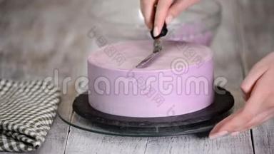 用<strong>紫色</strong>奶油盖装饰<strong>蛋糕</strong>的过程。 甜点师使用糕点抹刀将饼干奶油切等。