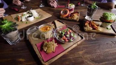 一张木制桌子的特写镜头，上面有素菜小吃，装饰精美，由服务员端上来