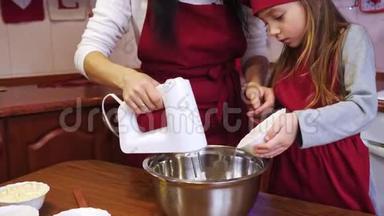 一个女儿在碗里加了一个糖，妈妈用搅拌机搅拌配料