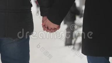 情侣们携手漫步在冬日花园的特写镜头上