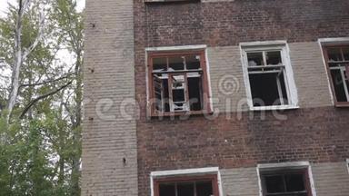 废弃的建筑打破了窗户，玻璃碎片和破破烂烂的麻布条随风飘扬。