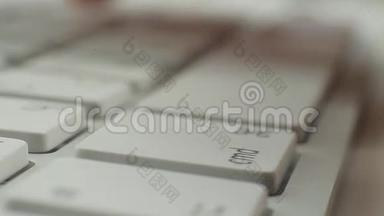 宏视频人手指打字按钮在白色键盘上。