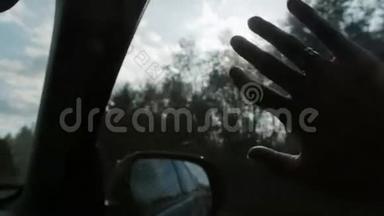 阳光透过手指和树木。 车上车窗上戴着戒指。 手指掌。 特写镜头。 慢节奏
