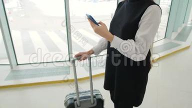 女游客在国际机场航站楼携带行李使用智能手机。 <strong>语音</strong>识别短信<strong>命令</strong>