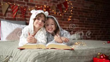 快乐可爱的<strong>孩子</strong>们穿着温暖的圣诞睡衣，笑着看着相机，微笑的<strong>孩子</strong>们在<strong>看书</strong>。
