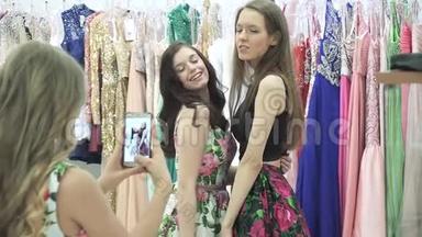 年轻女孩在更衣室购物中心用手机摄像头拍下女友的照片