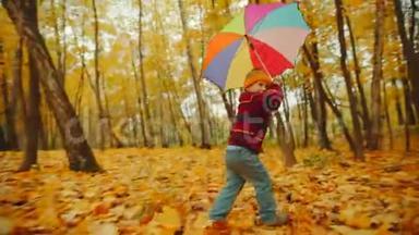 快乐的小男孩正在<strong>伞下</strong>的秋天公园里散步