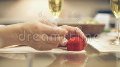 男人给红盒子带订婚戒指，向女朋友<strong>求婚</strong>，请求一只手，在室内。