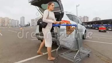 美丽的家庭主妇在停车场的<strong>汽车</strong>上从<strong>超市</strong>装包
