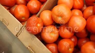 一个女人在蔬菜货架上的超市里买蔬菜和水果。 男人从腐烂的蔬菜中选择西红柿