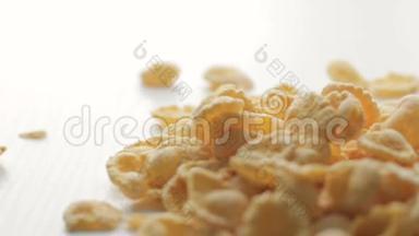 金色的玉米片掉落在白色桌子上的脚印，柔和地聚焦在中间的地面上