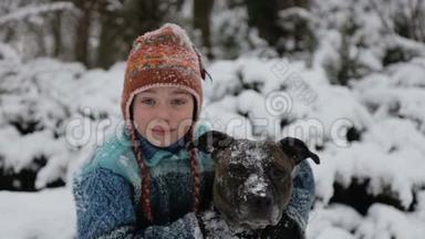 公园冬天带着一只猎犬的婴儿画像。 一个男孩在冬天和一只狗玩。
