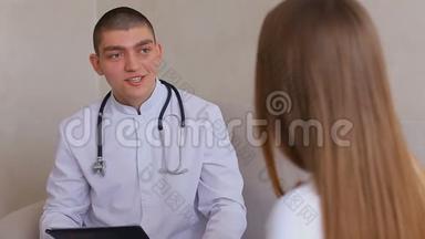 男医生为坐在灰色沙发背景下的医务室接待处的女孩提供指导和建议