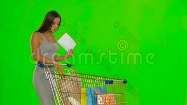 女人检查购物清单。 绿色屏幕