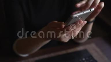 一个年轻的时髦女孩在咖啡馆的智能手机上上网