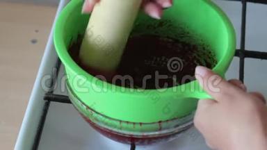 一个女人把煮好的糖煮的蔓越莓用香菜<strong>揉搓</strong>。 为棉花糖准备土豆泥。